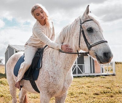 Buy stock photo Shot of a young female on top of a horse on a farm