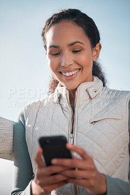 Buy stock photo Shot of an attractive young woman standing alone on her farm and using her cellphone