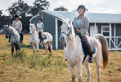 Buy stock photo Cropped portrait of an attractive young woman horse riding on a farm with her friends in the background
