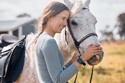 Buy stock photo Cropped shot of an attractive young woman standing with her horse on a ranch