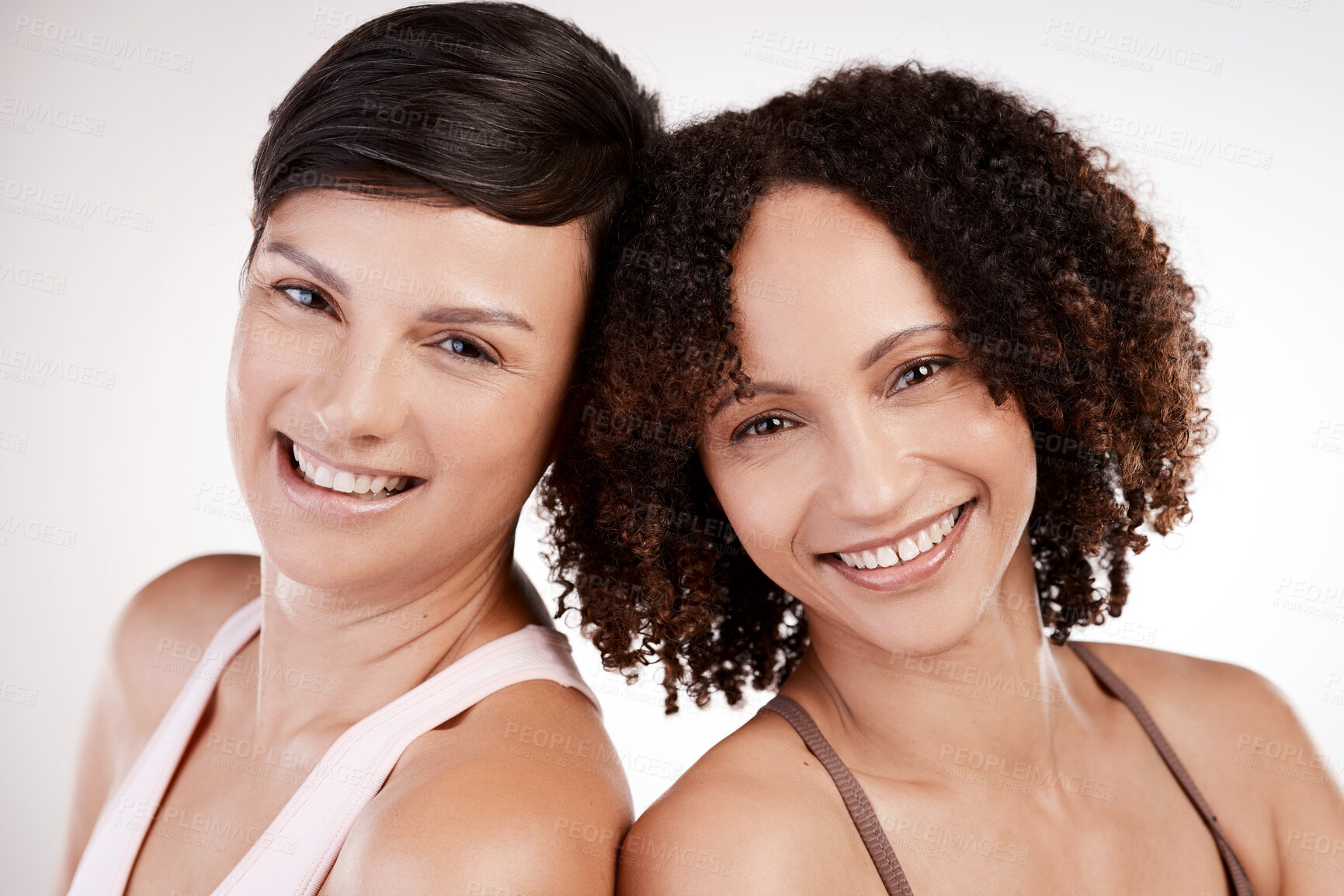 Buy stock photo Cropped portrait of two attractive young female athletes posing in studio against a grey background