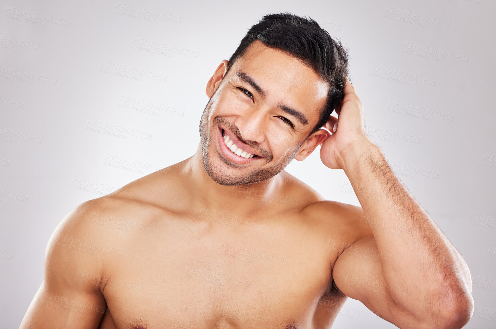 Buy stock photo Cropped studio portrait of a handsome young man playfully posing against a grey background