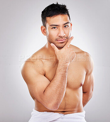 Buy stock photo Cropped studio portrait of a handsome young man posing against a grey background