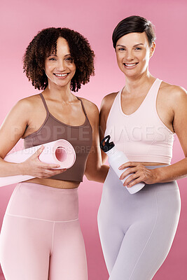 Buy stock photo Cropped portrait of two attractive young female athletes posing in studio against a pink background