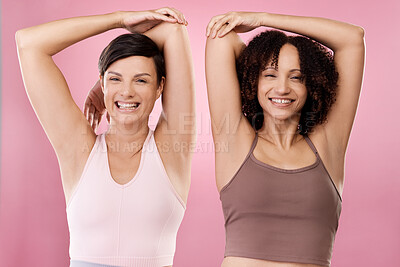 Buy stock photo Cropped portrait of two attractive young female athletes warming up in studio against a grey background