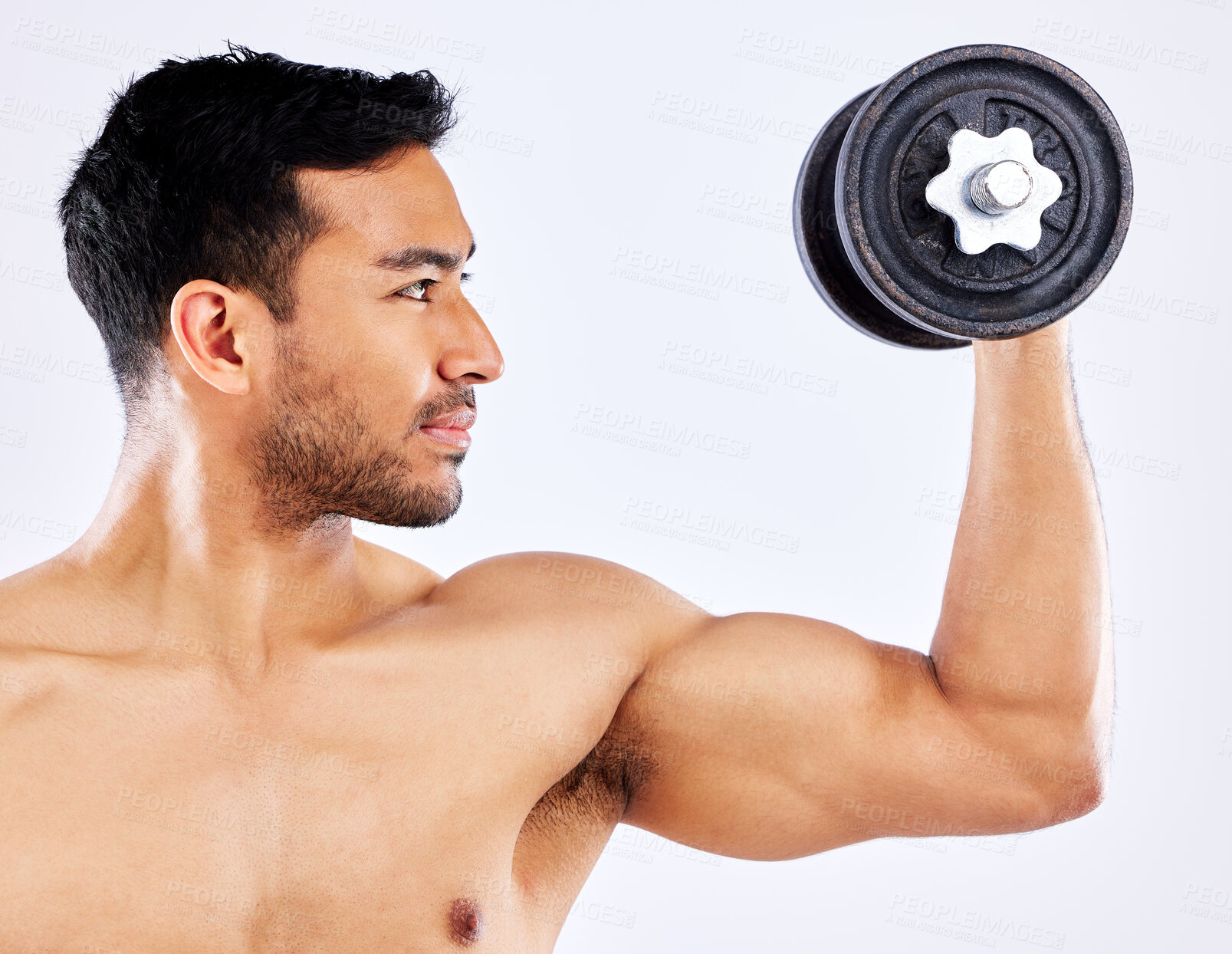 Buy stock photo Shot of a young man flexing his bicep muscles while holding a weight against a studio background