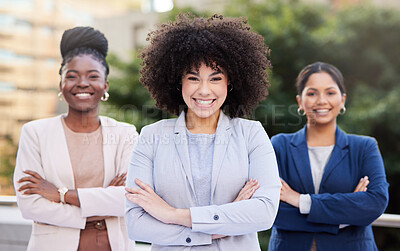 Buy stock photo Shot of a diverse group of businesswomen standing outside on the balcony with their arms folded