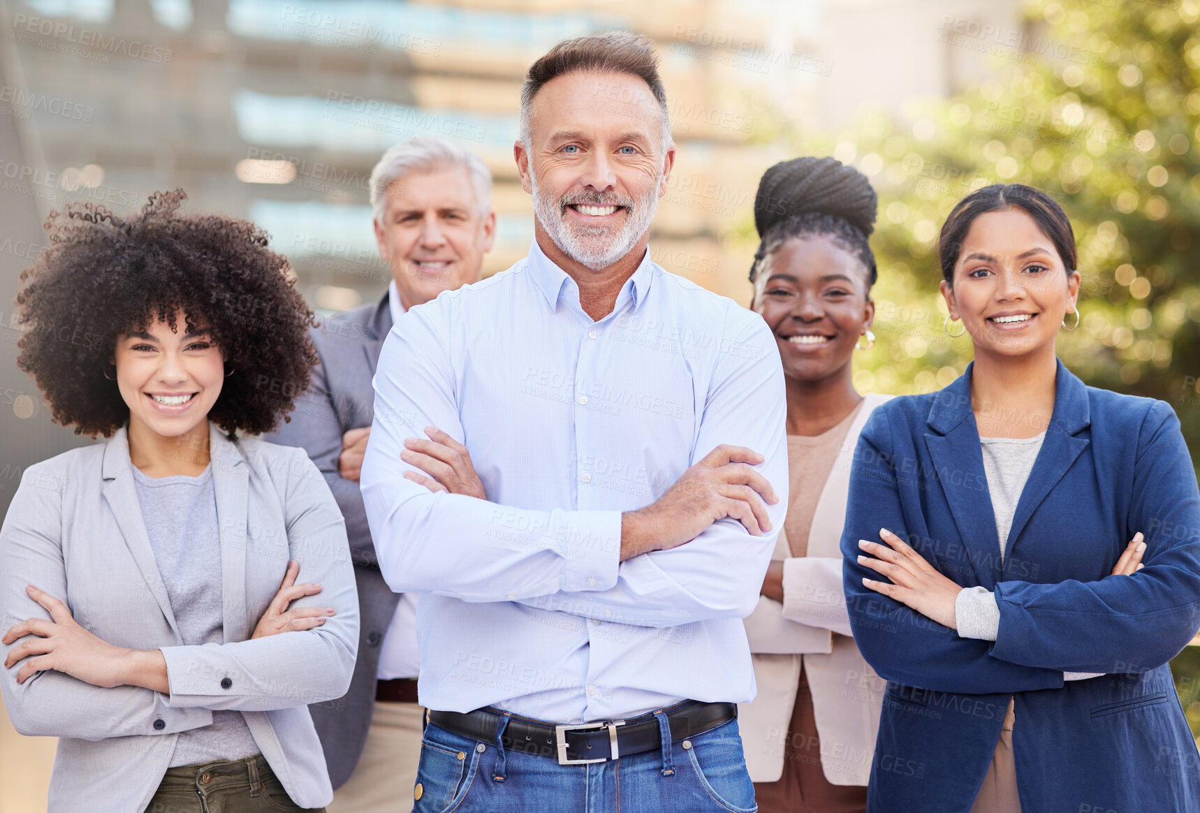 Buy stock photo Shot of a diverse group of businesspeople standing outside on the balcony with their arms folded