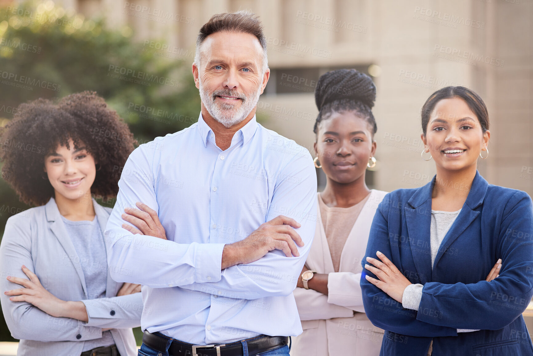 Buy stock photo Shot of a diverse group of businesspeople standing outside on the balcony with their arms folded