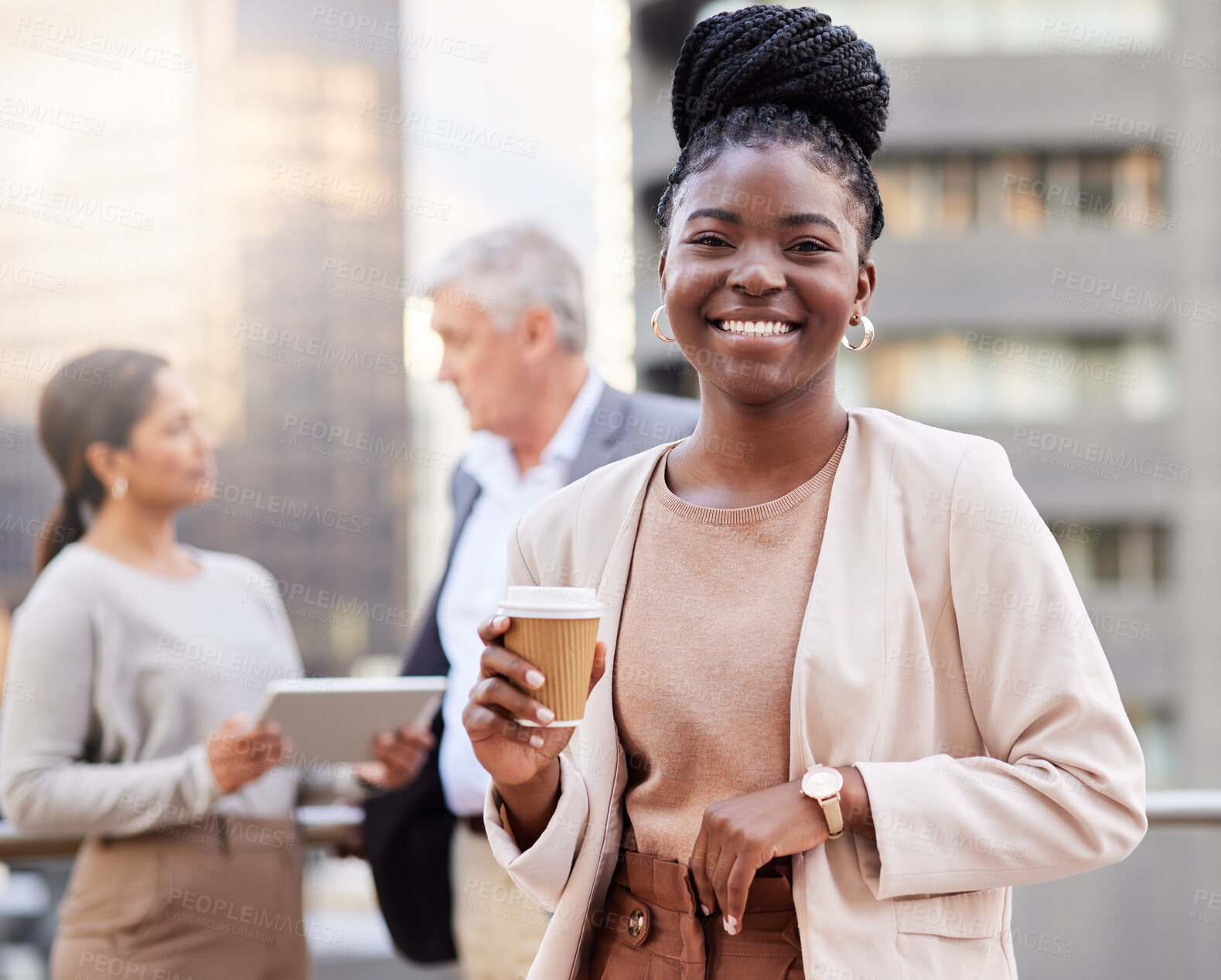 Buy stock photo Shot of an attractive young businesswoman standing outside and holding a cup of coffee while her colleagues discuss behind her