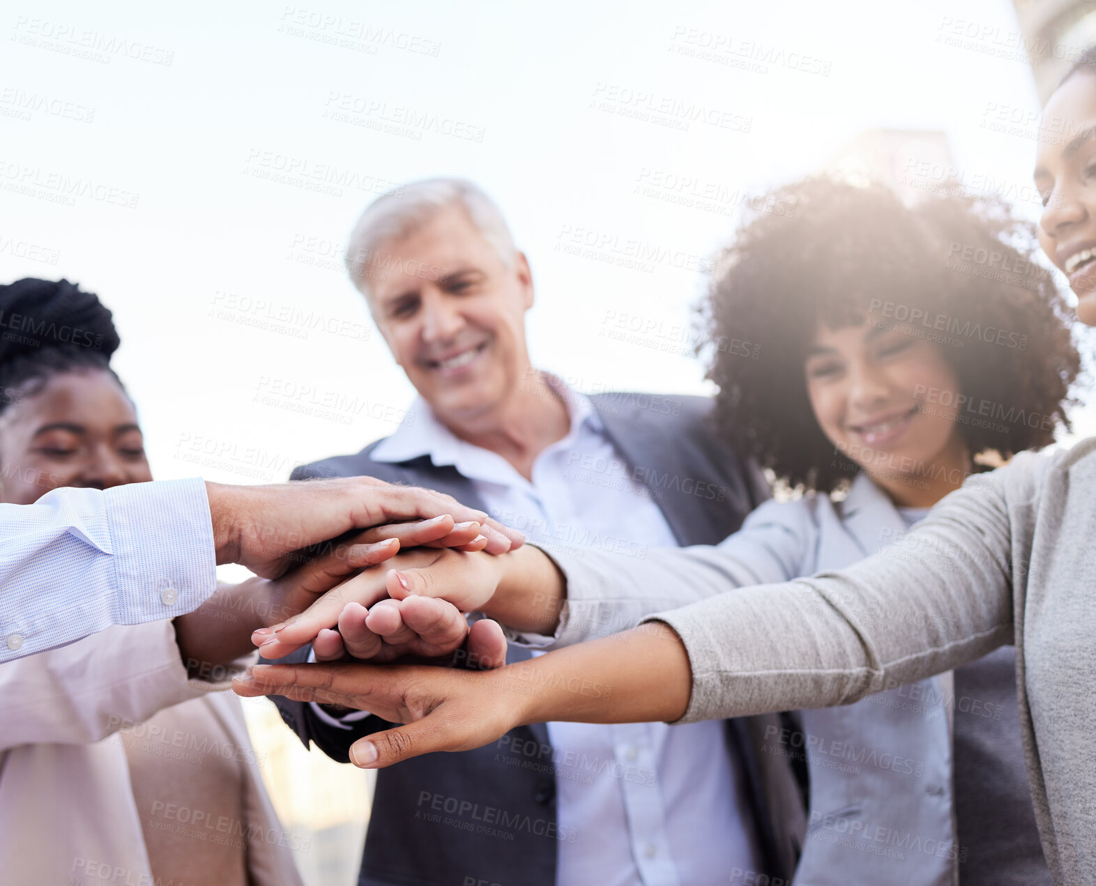 Buy stock photo Shot of a diverse group of businesspeople standing huddled together with their hands piled in the middle