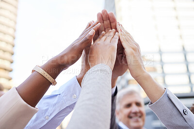 Buy stock photo Shot of an unrecognisable group of businesspeople huddled outside together with their arms raised and hands in the middle