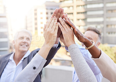 Buy stock photo Shot of a diverse group of businesspeople huddled outside together with their arms raised and hands in the middle