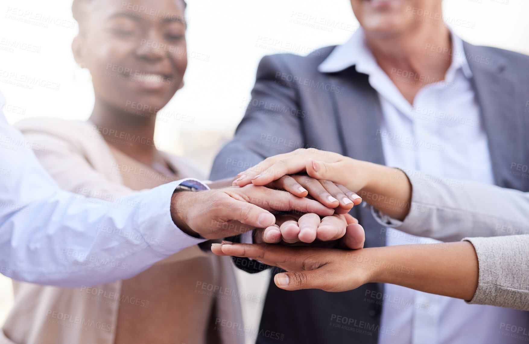 Buy stock photo Shot of a diverse group of businesspeople standing huddled together with their hands piled in the middle