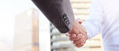 Buy stock photo Cropped shot of two unrecognisable businessmen standing outside on the balcony together and shaking hands