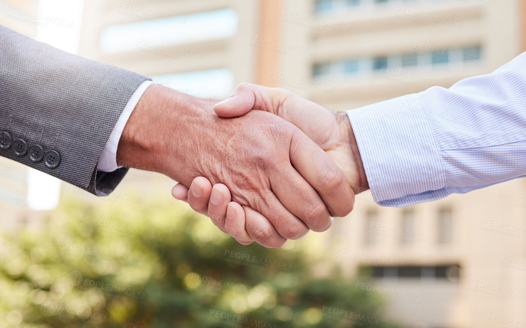 Buy stock photo Cropped shot of two unrecognisable businessmen standing outside on the balcony together and shaking hands