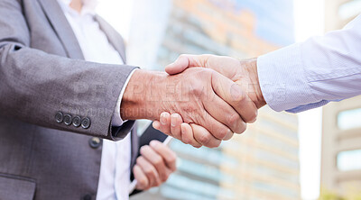 Buy stock photo Cropped shot of two unrecognisable businessmen standing outside on the balcony together and shaking hands