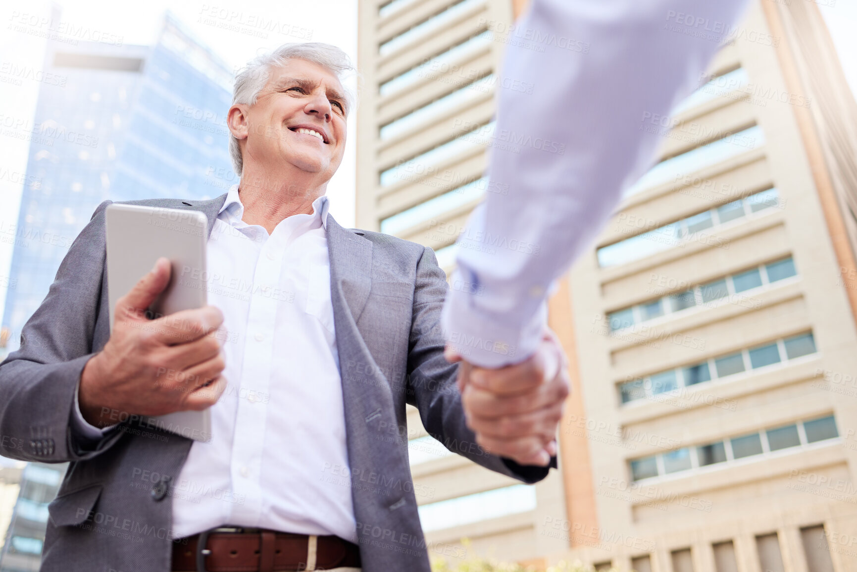 Buy stock photo Low angle shot of two businessmen standing outside on the balcony together and shaking hands