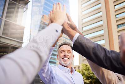 Buy stock photo Shot of a diverse group of businesspeople huddled outside together with their arms raised and hands in the middle