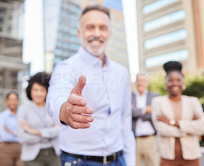 Buy stock photo Shot of an unrecognisable businessman standing with his hand outstretched for a handshake while his colleagues stand behind him