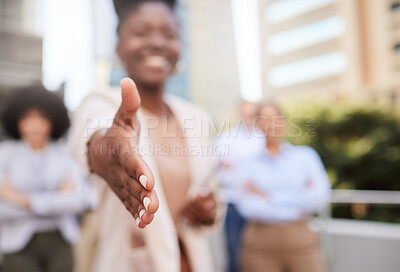 Buy stock photo Shot of an unrecognisable businesswoman standing with her hand outstretched for a handshake while her colleagues stand behind her