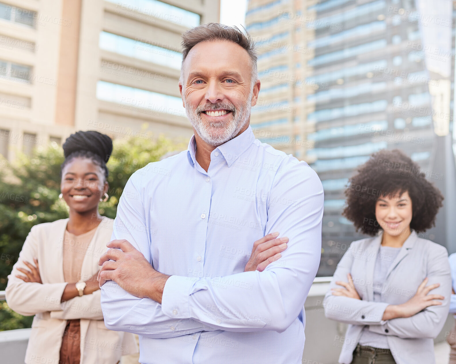 Buy stock photo Shot of a diverse group of businesspeople standing outside on the balcony with their arms folded