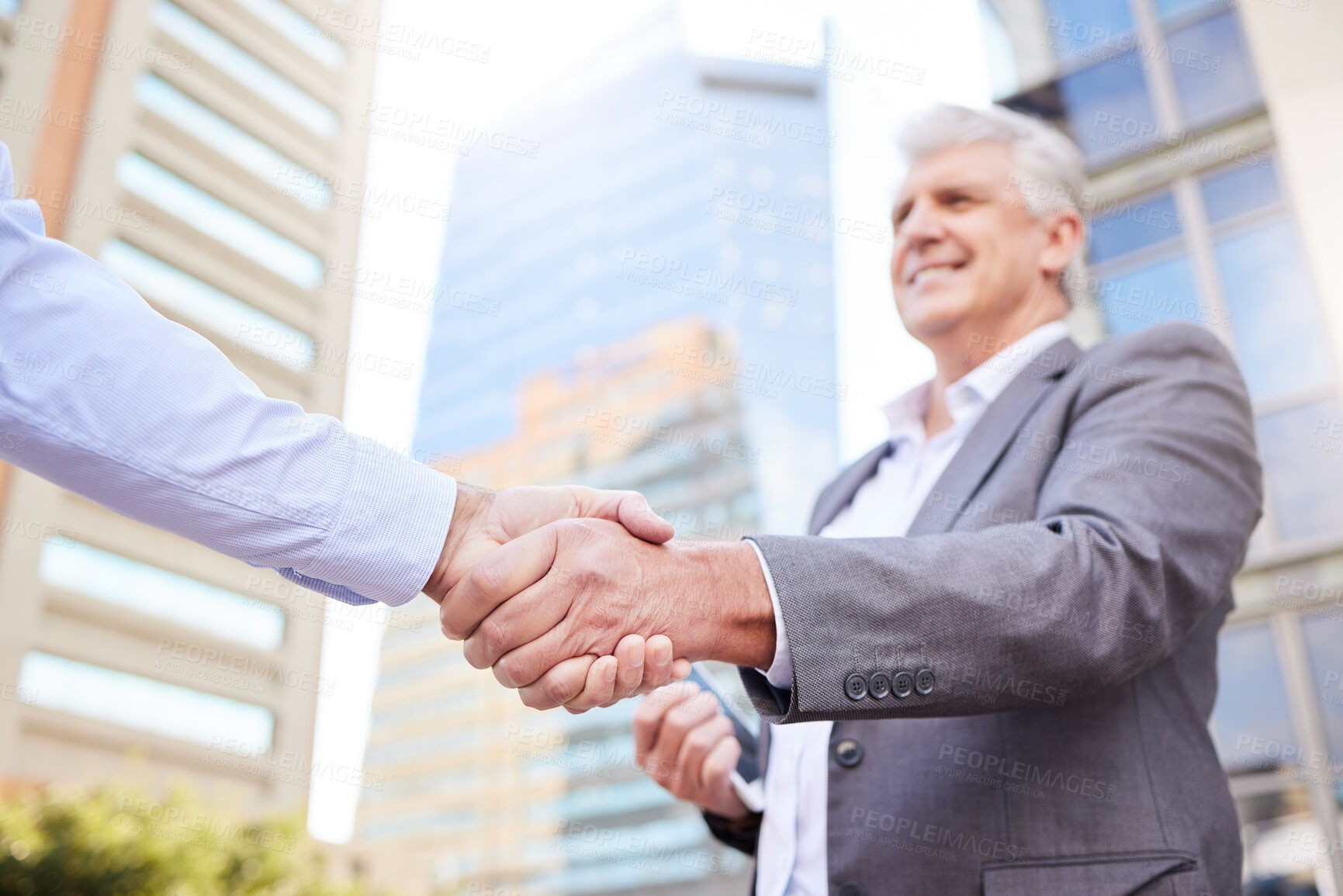 Buy stock photo Shot of two businessmen standing outside on the balcony together and shaking hands