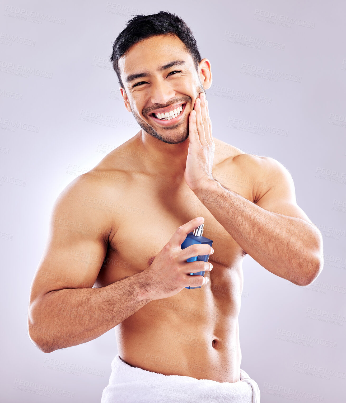 Buy stock photo Studio shot of a handsome young man applying aftershave