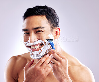 Buy stock photo Cropped shot of a handsome young man shaving his facial hair