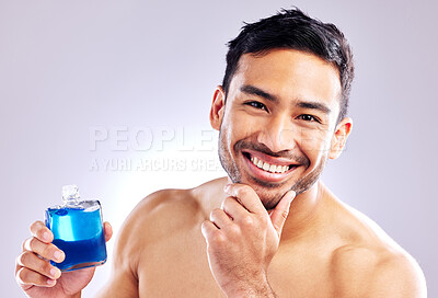 Buy stock photo Studio shot of a handsome young man applying aftershave