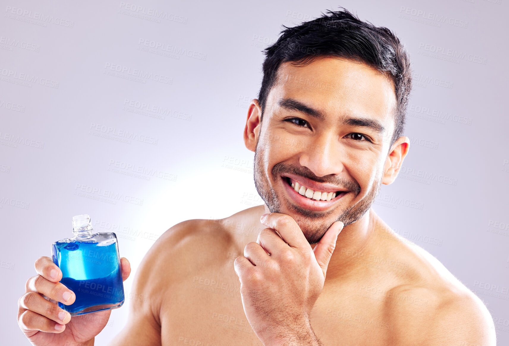 Buy stock photo Studio shot of a handsome young man applying aftershave