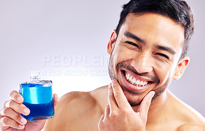 Buy stock photo Studio shot of a handsome young man applying aftershave