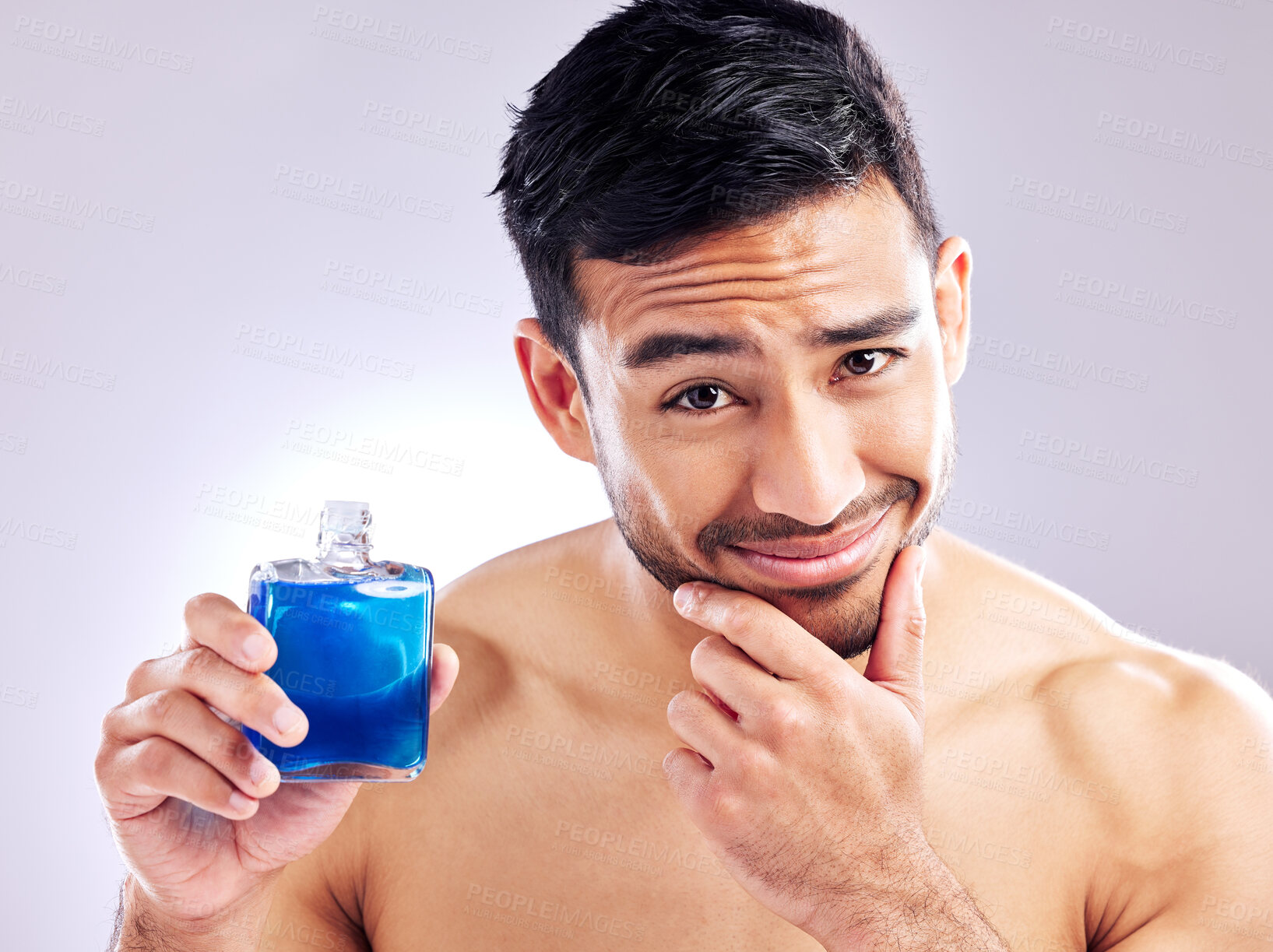 Buy stock photo Studio shot of a handsome young man applying aftershave
