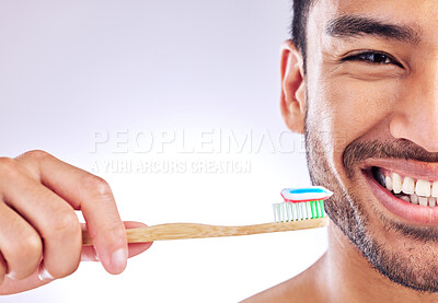 Buy stock photo Studio shot of a handsome young man holding up his toothbrush