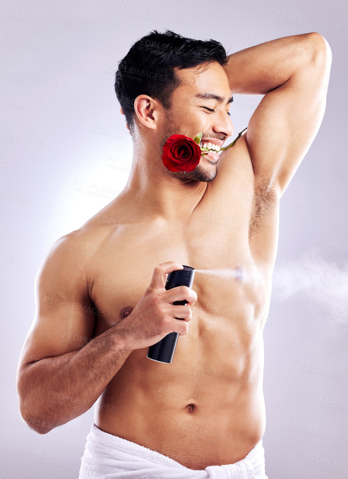 Buy stock photo Man, grooming and smile with deodorant and rose in studio background for hygiene, cleanliness and wellness. Male person, happy and confident with spray for odor, fragrance and freshness or healthcare