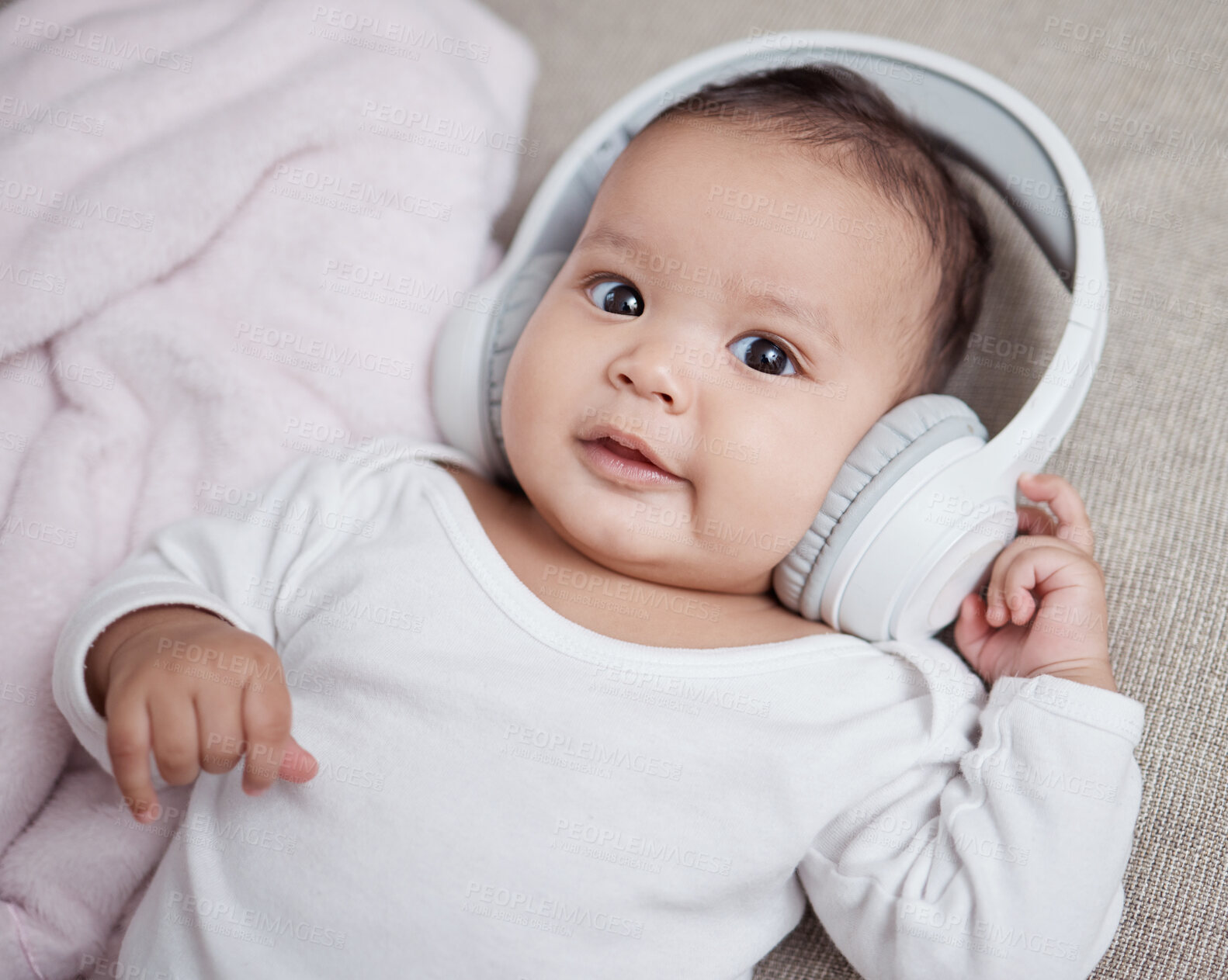 Buy stock photo High angle shot of an adorable baby wearing headphones at home