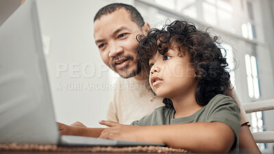 Buy stock photo Shot of a little boy using a laptop while sitting at home with his father