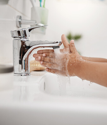 Buy stock photo Closeup shot of an unrecognisable little boy washing his hands at a tap in a bathroom at home