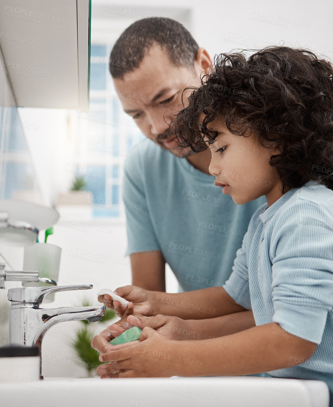 Buy stock photo Shot of a father helping his son wash his hands at a tap in a bathroom at home