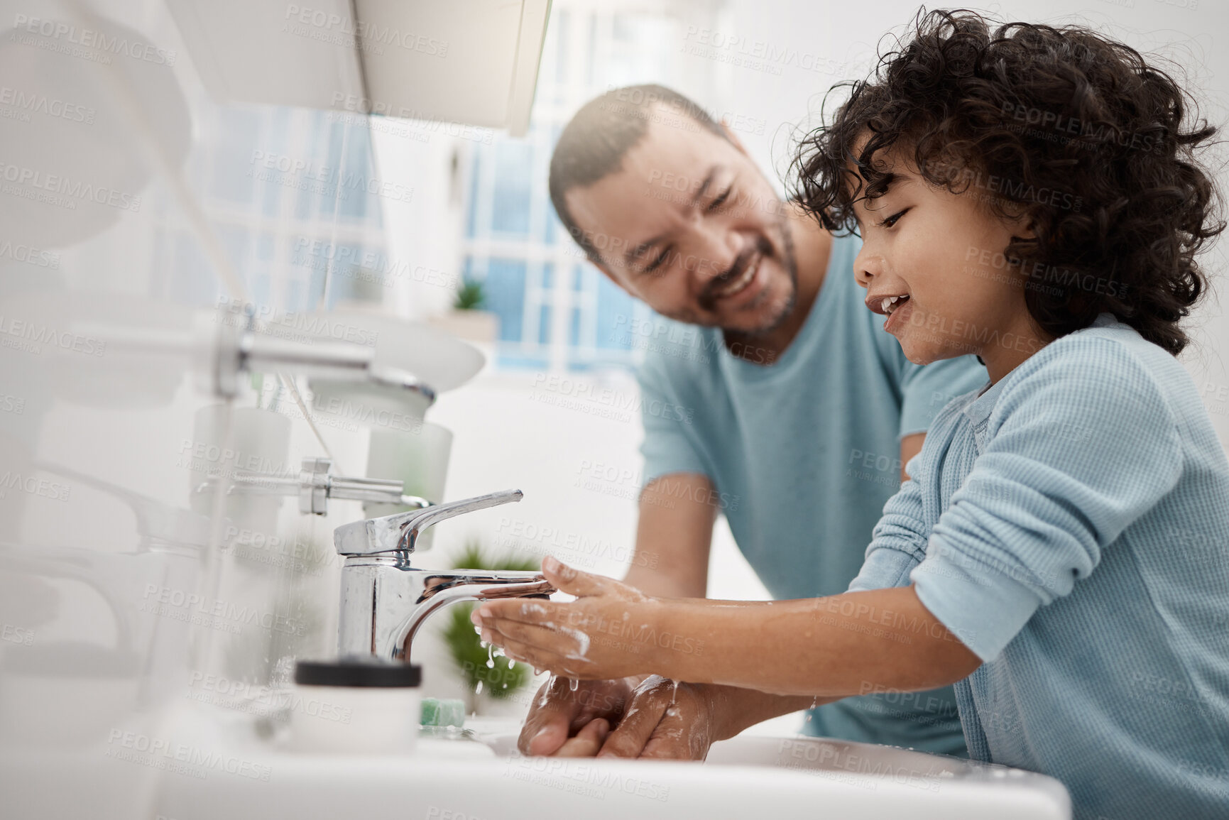 Buy stock photo Shot of a father helping his son wash his hands and face at a tap in a bathroom at home