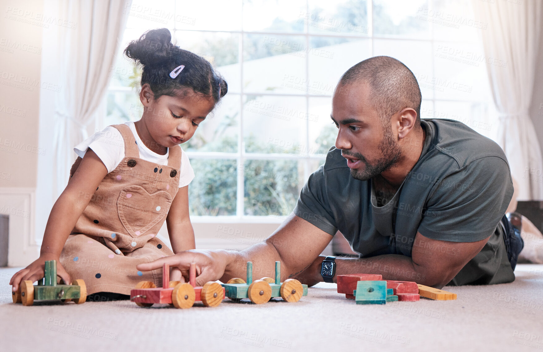 Buy stock photo Shot of a father and his little daughter playing with wooden toys together at home