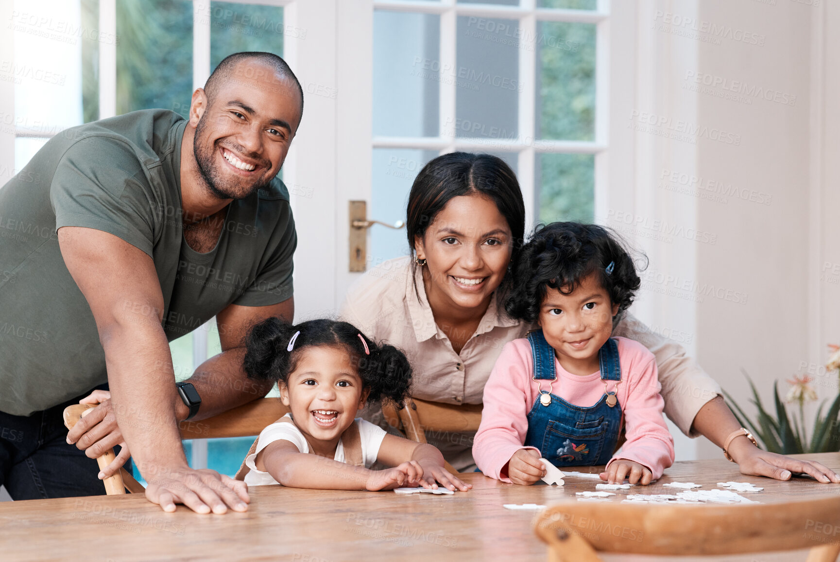 Buy stock photo Portrait of a happy family building a puzzle together at home