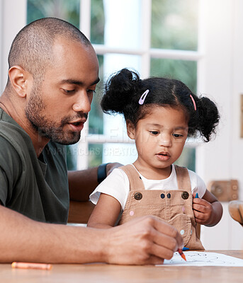 Buy stock photo Shot of a father colouring in a picture with his little daughter at home