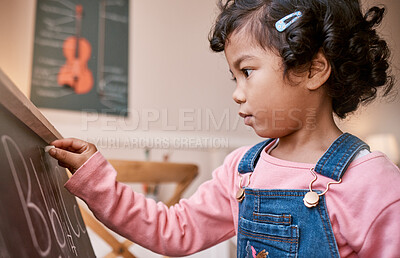Buy stock photo Shot of a little girl writing on a blackboard at home