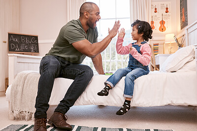 Buy stock photo Shot of a young father and daughter giving each other a high five at home