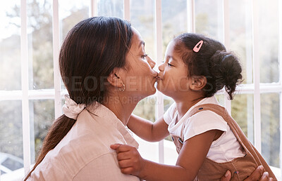 Buy stock photo Shot of a young mother giving her daughter a kiss at home