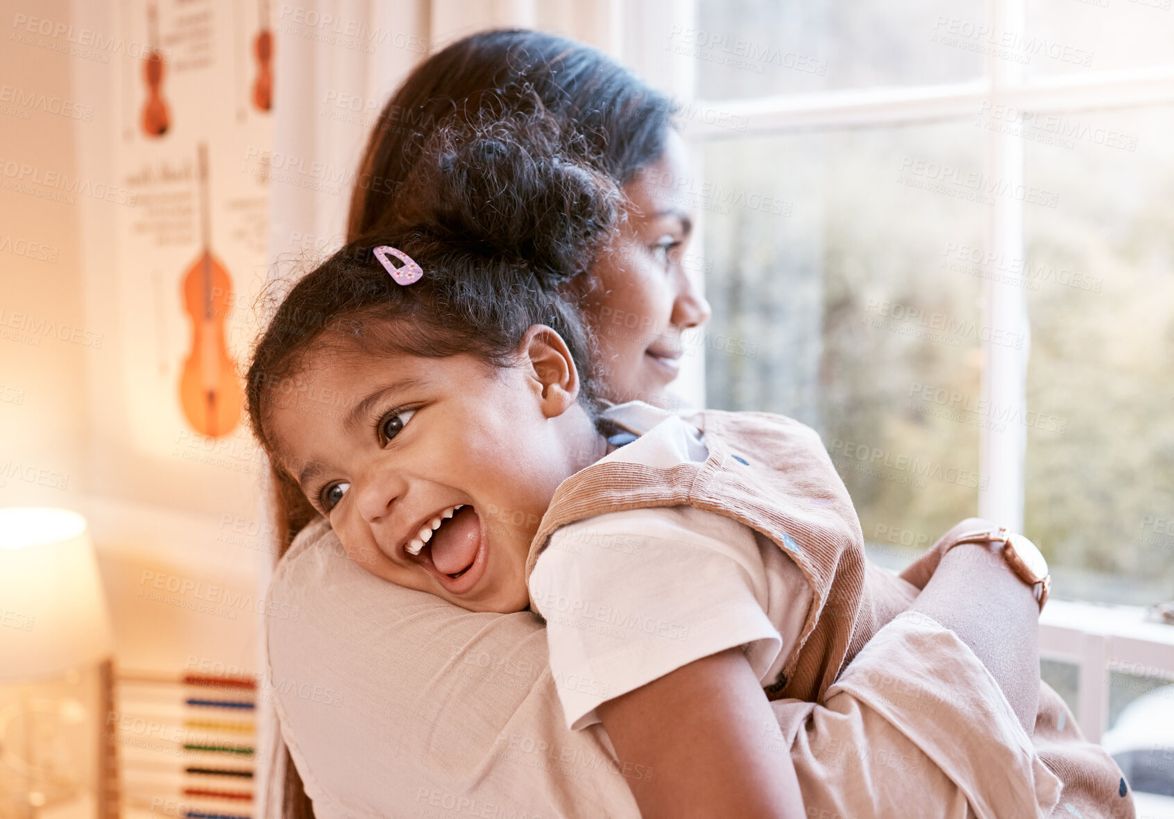 Buy stock photo Shot of a young mother embracing her daughter at home