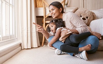 Buy stock photo Shot of a little girl looking out of the window with her mother at home