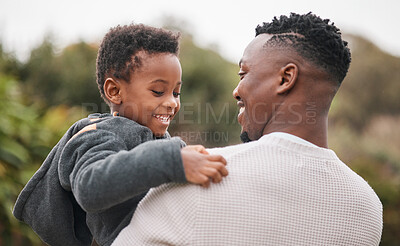 Buy stock photo Shot of an adorable little boy being carried by his father while bonding together outdoors