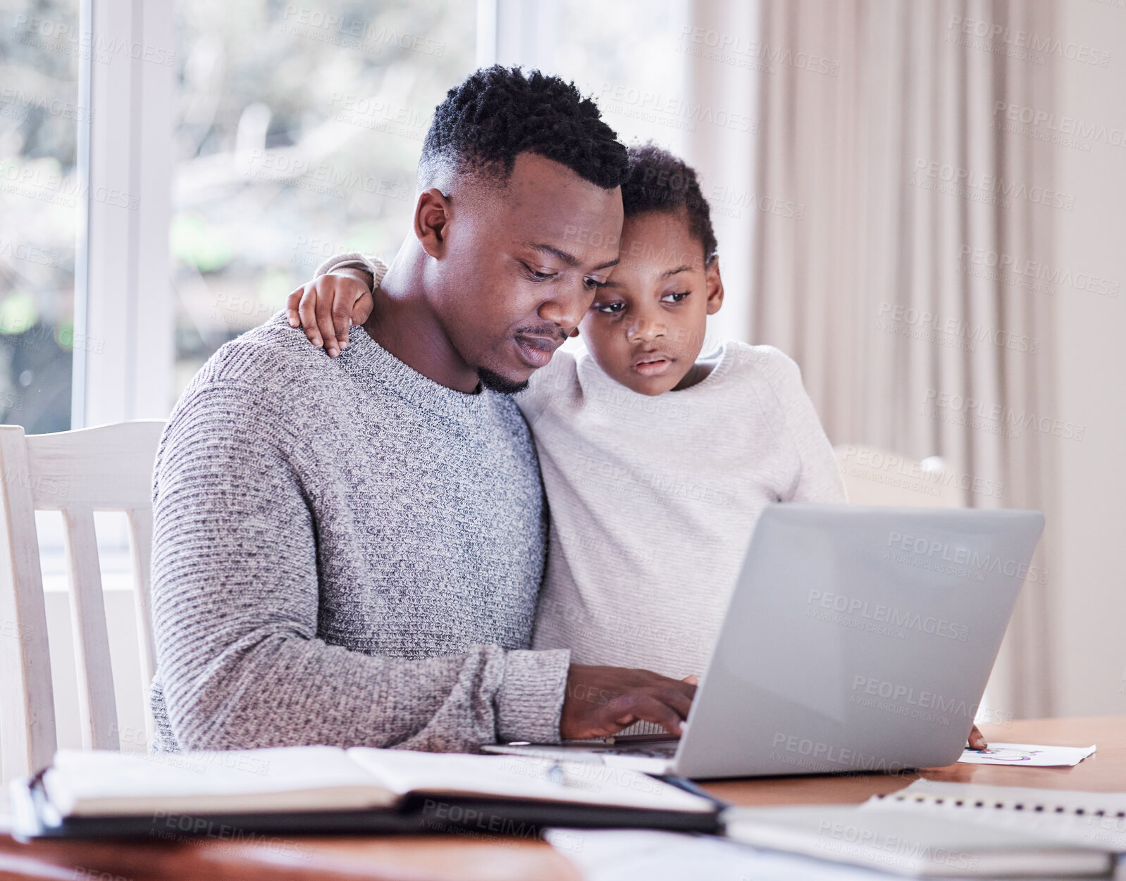 Buy stock photo Shot of a young man working while caring for his adorable baby girl at home